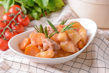 Bowl with tasty beef stew on table