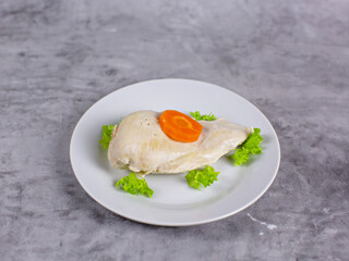 Chicken fillet with carrots on a white plate