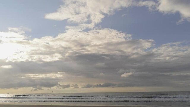 Panoramic aerial of the setting sun filtering through high clouds on the horizon, North Sea, Belgium
