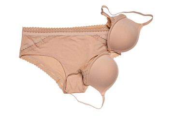 Women lingerie isolated. Close-up of beige or flesh-colored bra and panties isolated on a white background. Useful for wearing under bright or transparent dresses. Underwear fashion.