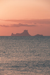 The magic, famous rock of Es Vedra, Ibiza, from the port of Formentera. Ibiza's most popular icon and symbol, said to be magic and mysterious. Soft pink sunset light.