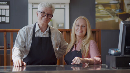 Portrait Of Senior Male And Female Coffee Shop Owners Standing At Sales Desk