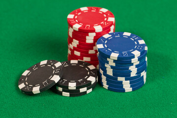 Blue, Red and Black Casino Poker Chips. Pattern Isolated on Green Background Table.