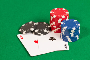Pocket Aces, Hand Pair, Two Playing Cards and Blue, Red and Black Casino Poker Chips. Pattern Isolated on Green Background Table.