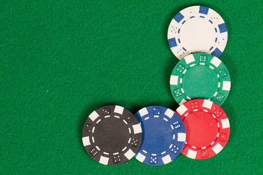 Blue, Red, White, Green and Black Casino Poker Chips. Frame with space for text. Pattern Isolated on Green Background Table.