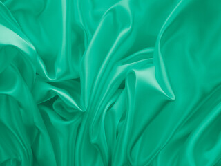 Obraz premium Beautiful elegant wavy light green satin silk luxury cloth fabric texture, abstract background design. Card or banner.