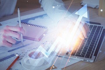 Fototapeta premium Growing arrows with businessman working on computer on background. Success concept. Double exposure.