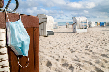 Face mask and empty beach chairs