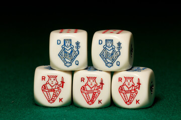 Playing poker dice full house closeup on green background