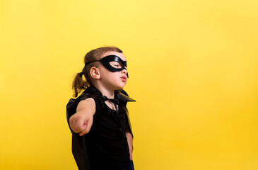 The masked hero girl stands sideways on a yellow isolated background with space for text