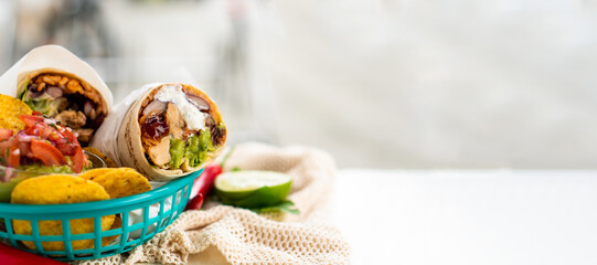 Mexican traditional authentic homemade Burrito with pulled pork beef chili con carne serve with tomato salad and avocado guacamole and dip sauce