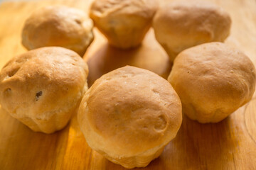 Close-up of fresh homemade muffins with raisins on a wooden surface. Shallow depth of field, selective focus. Home cooking