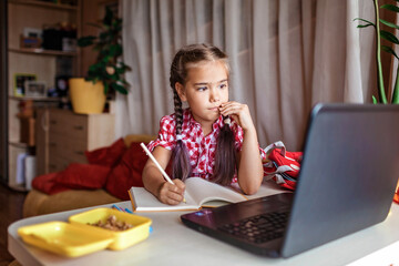 Distant education, back to school. Girl studying homework during online lesson at home
