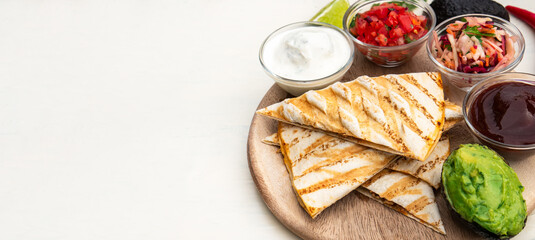 Mexican traditional authentic homemade quesadilla with pulled pork beef chili con carne serve with tomato salad and avocado guacamole and dip sauce