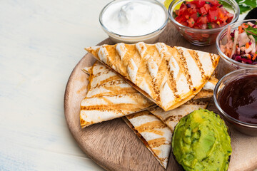 Mexican traditional authentic homemade quesadilla with pulled pork beef chili con carne serve with tomato salad and avocado guacamole and dip sauce