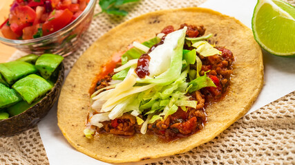 Mexican traditional authentic homemade tacos with pulled pork beef chili con carne serve with tomato salad and avocado guacamole and dip sauce
