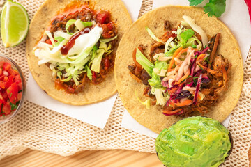 Mexican traditional authentic homemade tacos with pulled pork beef chili con carne serve with tomato salad and avocado guacamole and dip sauce