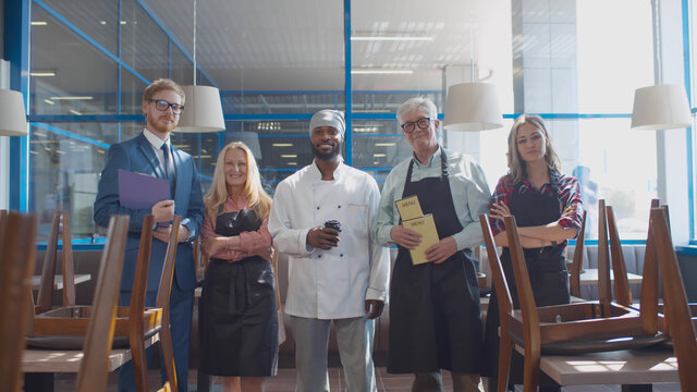 Portrait of happy diverse friendly cafe team welcoming guests after quarantine