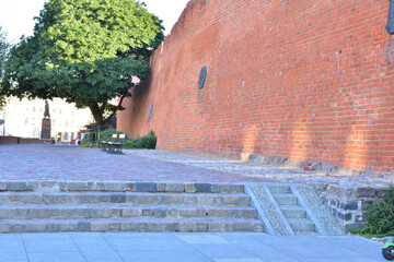 The historic defense walls of the Barbican in Warsaw's Old Town during sunrise.