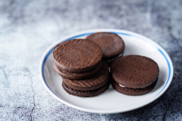 Chocolate cookies with cream filling with cups of tea