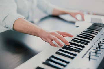 young man's hands playing keyboard piano, composing music , music record concep, art