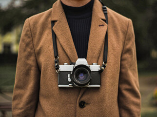 Stylish man in coat with film camera, photographer