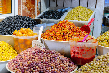 Olive shop with different types of olives in containers in a market