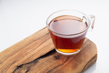 Black tea in a glass cup on a white background