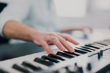 Obraz premium young man's hands playing keyboard piano, composing music , music record concep, art, song composition, melody