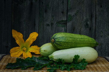 Flowers, leaves and fruits of zucchini isolated on a wooden background