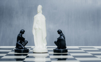 Black and white chess pieces on the chessboard. The concept of combating racism. Motivational poster against racism and discrimination.