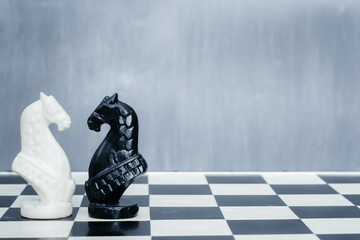 Black and white chess pieces on the chessboard. The concept of combating racism. Motivational poster against racism and discrimination.