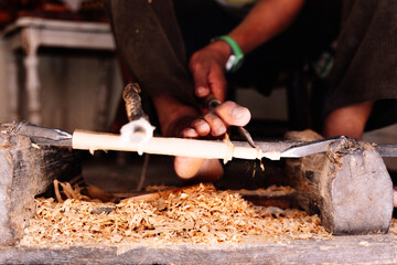 Detail of the extremities of a man working with wood in a workshop