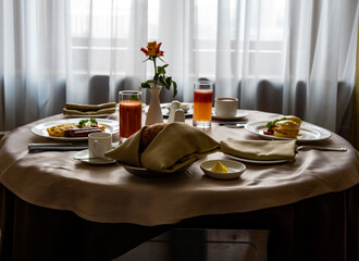 breakfast with a rose in a vase for two against the background of a window
