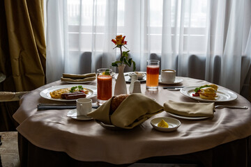breakfast with a rose in a vase for two against the background of a window