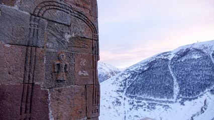 Gergeti Trinity Church at dawn in the snowy mountains near Stepantsminda, Georgia.
