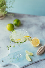 Glass of cucumber cocktail or mocktail, refreshing summer drink with crushed ice and sparkling water on a wooden background