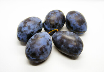 Ripe fresh prunes on a white background