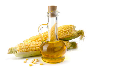 Corn oil in a carafe, peeled corn cobs and grains, text space isolated on a white background