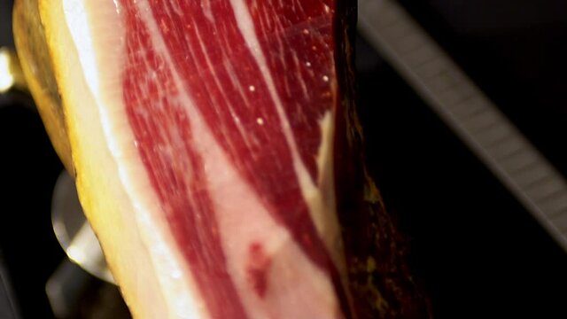 175/5000
view from above of a leg of iberico ham where you can see the detail of the streaks of different red and white colors of the meat of the delicious pork appetizing to eat