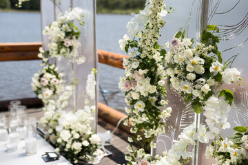 Close up of wedding ceremony with white transparent screens and fresh white flowers and candles
