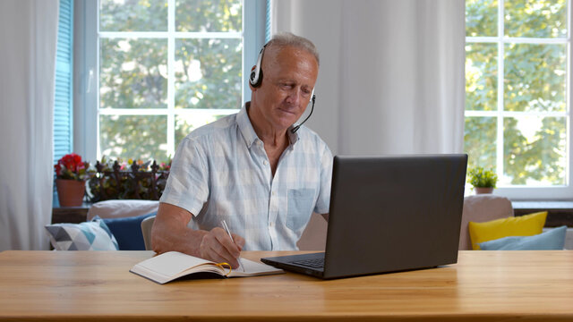 Focused Mature Businessman Wear Headphones Study Online Watching Webinar