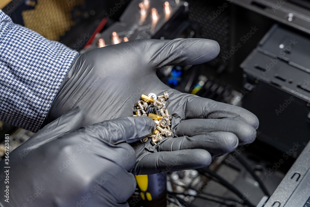 Poster computer technician selects metal screw to assemble computer. assembling desktop pc