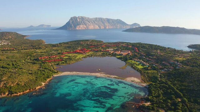 Breathtaking spring scene of Salina Bamba beach with Tavolara mountain on background, Sardinia island, Italy. 4k drone flight moving to the side footage (Ultra High Definition).
