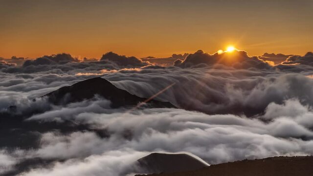 A mesmerizing time-lapse of the sun rising above the sea of smoke-like clouds. A summit view of daybreak promising a new day, static shot.