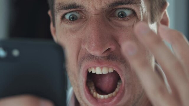 Angry troubled stressed business man having problem while using smartphone