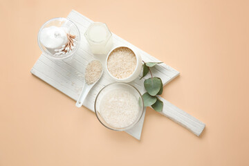 Healthy rice water with cosmetic supplies on color background