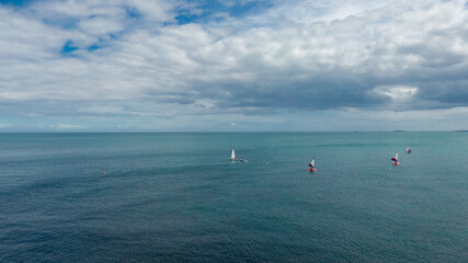Fototapeta na wymiar Aerial view on the windsurfers. Sea from air. Summer seascape from drone, Famous place in Whitehead, Northern Ireland, united Kingdom 