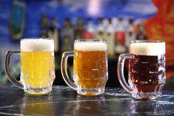 Glasses with different sorts of craft beer. Red, bronze and white beer in beer glasses on the bar....