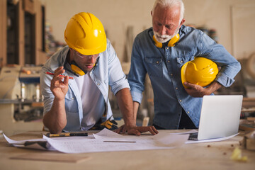 Woodworkers watching at the blueprints